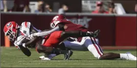  ?? (NWA Democrat-Gazette/Charlie Kaijo) ?? Arkansas cornerback Jerry Jacobs (right) tackles Georgia wide receiver Dominick Blaylock during the first half. Jacobs, a senior graduate transfer from Arkansas State University, made his first start for the Razorbacks.