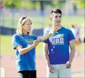  ??  ?? High school sprinter Michael Aono consults with Thunderbir­ds track club coach Mary Chewning during practice earlier this week.