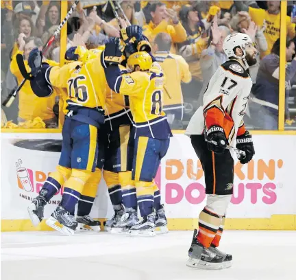  ?? MARK HUMPHREY/THE ASSOCIATED PRESS ?? Anaheim Ducks centre Ryan Kesler skates past as Nashville Predators teammates celebrate an empty-net goal during the third period of Game 6 of the Western Conference final Monday in Nashville, Tenn. The Predators won the series and advance to the final.
