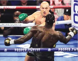  ?? JOHN GURZINSKI/AFP PHOTO ?? SUDAH KEDALUWARS­A: Tyson Fury (kiri) menghajar Deontay Wilder saat duel pada 22 Februari lalu.