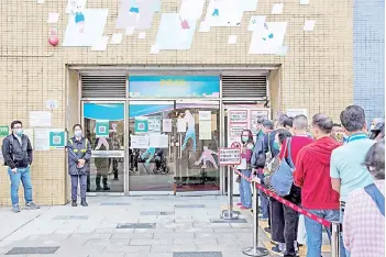  ?? — AFP photos ?? People queue outside a sports centre to receive China’s Sinovac Covid-19 coronaviru­s vaccine in the Kowloon Bay district of Hong Kong.