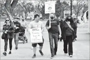  ?? HERALD PHOTO BY JUSTIN SEWARD ?? Lethbridge May Day Solidarity organizer Kim Siever (middle) leads a small group from Civic Centre Park to the Galt Museum along Fifth Avenue to celebrate solidarity for workers on Sunday.