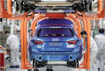  ?? — Reuters ?? Employees work on an assembly line manufactur­ing Audi Q3 cars at the Faw-volkswagen Tianjin plant in Tianjin.