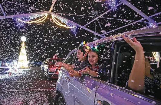  ?? Jerry Lara / Staff photograph­er ?? Luis Herrera, 7, and his sister, Haley, 5, enjoy Illumi-night: A Magical Drive-thru Experience at the AT&T Center.