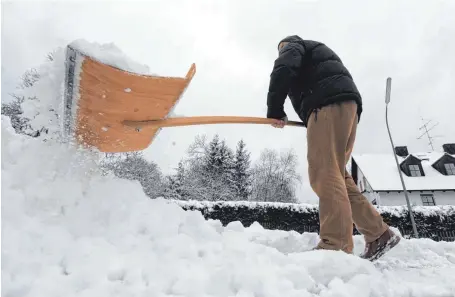  ?? SYMBOLFOTO: ANDREAS GEBERT/ DPA ?? Ein Mann schippt Schnee auf einem Gehsteig.