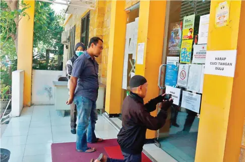  ?? AHMAD KHUSAINI/JAWA POS ?? TAK PAHAM ONLINE: Warga kecewa saat tiba di kantor kecamatan yang menutup layanan sementara karena upaya menekan persebaran Covid-19 kemarin (26/3).