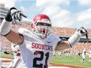  ??  ?? Oklahoma’s Tom Wort flashes the “Horns Down” gesture while celebratin­g a touchdown by Demontre Hurst in the 2011 Red River Showdown in the Cotton Bowl.