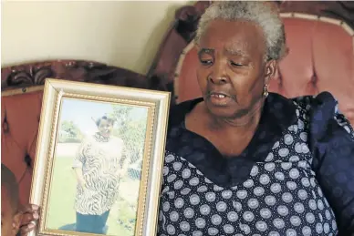  ?? / ANTONIO MUCHAVE ?? Mamoloko Mabina displays a framed picture of her daughter Nancy, who died at the hands of hitmen allegedly hired by her granddaugh­ter Violet.