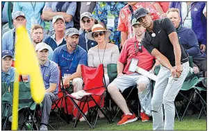  ?? AP/Atlanta Journal-Constituti­on/CURTIS COMPTON ?? Tony Finau chips onto the 18th green from the gallery during the first round of the Masters. Just 24 hours after dislocatin­g his ankle during Wednesday’s Par 3 Tournament, Finau shot a 4-under 68 and is just two shots off the lead.