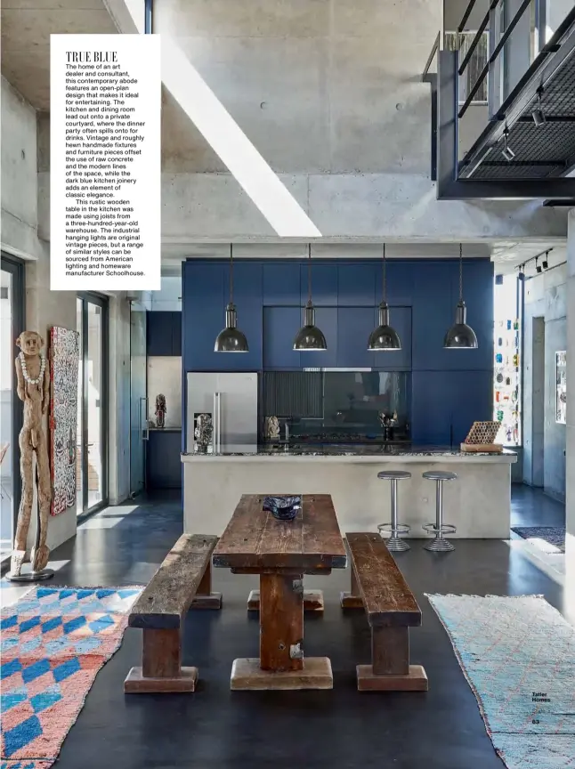  ??  ?? TRUE BLUE The home of an art dealer and consultant, this contempora­ry abode features an open-plan design that makes it ideal for entertaini­ng. The kitchen and dining room lead out onto a private courtyard, where the dinner party often spills onto for drinks. Vintage and roughly hewn handmade fixtures and furniture pieces offset the use of raw concrete and the modern lines of the space, while the dark blue kitchen joinery adds an element of classic elegance.
This rustic wooden table in the kitchen was made using joists from a three-hundred-year-old warehouse. The industrial hanging lights are original vintage pieces, but a range of similar styles can be sourced from American lighting and homeware manufactur­er Schoolhous­e.