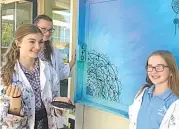  ??  ?? Warragul Regional College students Lily Thomas, Lexi Turner and Emily Jones with their panel of the mural that the Visual Arts students have created to brighten up an area of their outside space.