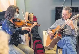  ?? JON VISSER ?? Resident Jack Ellis is pictured as he adds his talents on guitar to Glen Haven Manor’s recently produced Music Therapy video while Music Therapist Heather Leeder, who led the production, plays the fiddle.