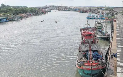  ?? TAWATCHAI KEMGUMNERD ?? Fishing vessels are docked on both sides of the Pattani River in Pattani’s Muang district.