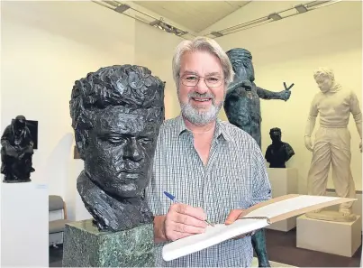  ?? Picture: Gareth Jennings. ?? Norman Atkinson signs the memory book alongside a self sculpture of the man himself.