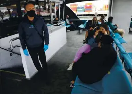  ?? ARIC CRABB — STAFF PHOTOGRAPH­ER ?? San Francisco Bay Ferry deckhand John Henri Nolette, left, makes sure passengers stay socially distanced during a trip to the San Francisco Ferry Building on Wednesday.