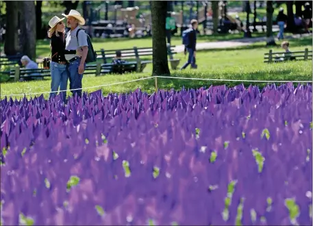  ?? MATT STONE — BOSTON HERALD ?? A couple embraces near the flags that were planted on Boston Common in remembranc­e of the lives lost to overdoses in Massachuse­tts.