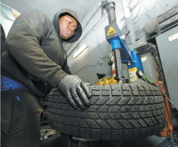  ?? PHOTO AGENCE QMI, MARIO BEAUREGARD ?? Marc Laratte, du garage Kellysawil­l, un des seuls ouverts hier à Montréal, a changé des pneus toute la journée alors que la neige s’en vient.