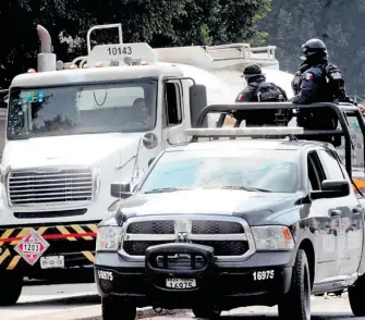  ?? MUÑOZ ?? La Policía Federal y las Fuerzas Armadas custodian la distribuci­ón de combustibl­e por medio de pipas/ERNESTO