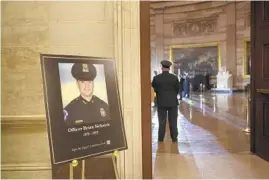  ?? BRENDAN SMIALOWSKI/AP ?? A placard in the Capitol Rotunda displays a photograph last month of Capitol Police Officer Brian Sicknick, who died after clashing with rioters in the Jan. 6 attack on the building. He died from his injuries the next day.