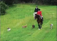  ?? Ernest A. Brown photo ?? Horses and hounds hunt simulated foxes in addition to leaping over five jumps.