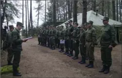  ?? THE ASSOCIATED PRESS ?? Belarus Col. Alexander Prokopenko, left, reads his orders at a training ground at an undisclose­d location in Belarus on Thursday.