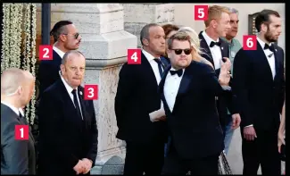  ??  ?? No time to chat: Corden waves as he walks past six security guards