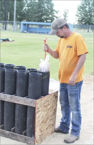  ?? Katie West • Times-Herald ?? Brett Glover with Premier Fireworks gently places a firework into a launching mechanism. Premier Fireworks provided the entertainm­ent for this year’s Fireworks in the Delta.