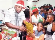  ??  ?? Pastor Charles Francis handing out gifts to the children at the Faith United Church of God Internatio­nal 9th Annual Christmas Treat at 53 Mandela Terrace, Kingston 11, on Sunday, December 23.