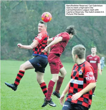  ??  ?? Bancffosfe­len Reserves’ Carl Gabrielson rises to meet a high ball in the Carmarthen­shire League clash with Caerbryn Reserves. The match ended 2-2. Picture: Phil Davies.