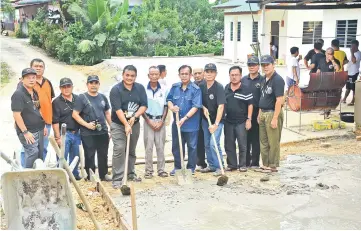  ??  ?? Jamit (sixth right) joins in the gotong-royong.