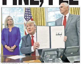  ??  ?? ‘PROUD’ PREZ: President Trump shows off his executive order Wednesday. Flanking him are Homeland Security boss Kirstjen Nielsen and Vice President Mike Pence.