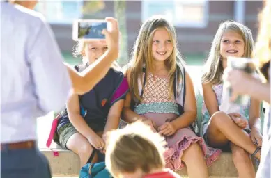  ?? STAFF PHOTOS BY ERIN O. SMITH ?? From left, friends Belou Anderson, 7, Becca Shelton, 7, and Anna Claire Harless, 8, pose for their moms at Nolan Elementary on Hamilton County’s first day of school Wednesday.