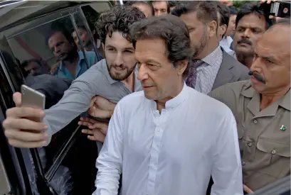  ?? AP ?? a supporter takes a selfie with imran Khan, head of the Pakistan tehreek-e-insaf, as he leaves a party meeting in islamabad on Monday. —