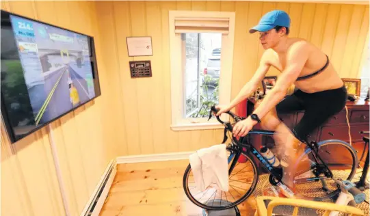  ?? ERIC WYNNE • THE CHRONICLE HERALD ?? Callum Myers, 17, cycles at his home in Dartmouth during a virtual fundraiser Sunday for Feed Nova Scotia. The ride was done through ZWIFT, an online portal that allows other riders to join from any location.