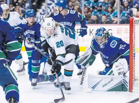  ?? DARRYL DYCK/THE CANADIAN PRESS ?? The San Jose Sharks’ Marcus Sorensen reaches for the puck in front of Canucks goalie Michael DiPietro as Vancouver forward Elias Pettersson gives chase at Rogers Arena on Monday night. DiPietro had his challenges in his NHL debut, allowing seven goals on 24 shots in a 7-2 Sharks victory. Evander Kane led San Jose with two goals.