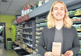  ?? MELISSA WONG/SPECIAL TO THE TELEGRAM ?? Assistant manager Jackson Mclean holds four red smile potato seeds in E.W. Gaze Seeds Co. in downtown St. John’s. The store is giving away red smile potato seeds to its customers to test.