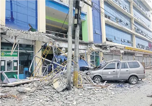  ??  ?? TEMBLOR SHOCK: Fallen debris from a building yesterday following a powerful 6.5 magnitude earthquake at night time that rocked Surigao City in the southern Philippine­s.