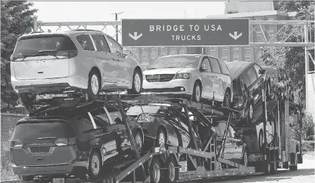  ?? DAN JANISSE ?? A truck loaded with Chrysler Pacifica models makes its way onto the Ambassador Bridge in Windsor, Ont., on Monday. Residents of the Southweste­rn Ontario city dread a potential 25-per-cent tariff on auto imports from Canada could devastate the...