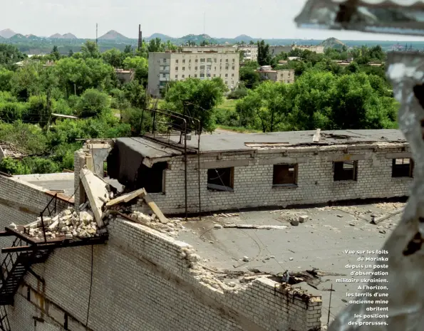  ??  ?? Vue sur les toits de Marinka depuis un poste d’observatio­n militaire ukrainien. A l’horizon, les terrils d’une ancienne mine abritent les positions des prorusses.