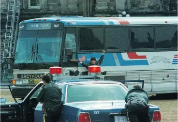  ?? WAYNE CUDDINGTON / / POSTMEDIA NEWS FILES ?? RCMP officers keep watch on hijacked bus on April 7, 1989, on Parliament Hill as a two-way radio is being handed to the driver.