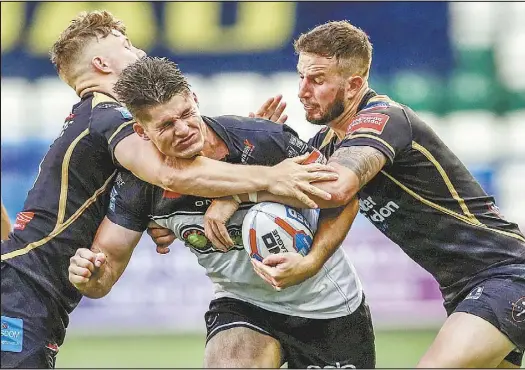  ??  ?? Left: It takes two men to tackle Charly Runciman, playing for Widnes Vikings! PHOTO: ACTION IMAGES/