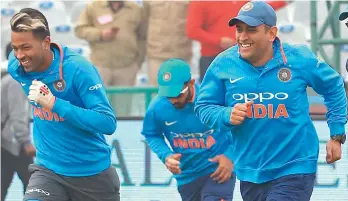  ??  ?? Cricketers Hardik Pandya (left) and M. S. Dhoni run during a training session in this file photo.