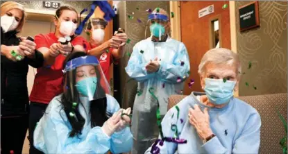  ?? STEPHEN DUNN / POOL VIA REUTERS ?? Confetti is popped by health workers after Jeanne Peters, 95, became the first nursing home patient in West Hartford, Connecticu­t, to receive a vaccinatio­n on Dec 18.