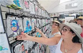  ?? ?? Cinde Weiser, right, and Karen Dibala grin at a pair of colorful socks on display during a previous Delray Affair in downtown Delray Beach. This year’s event is April 8-10. JOHN MCCALL/SUN SENTINEL FILE