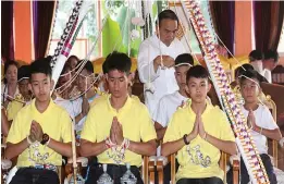  ?? — AP ?? Football coach Ekkapol Janthawong, second from left, and members of the rescued football team attend a Buddhist ceremony that is believed to extend the lives of its attendees in Mae Sai district, Thailand, on Thursday.