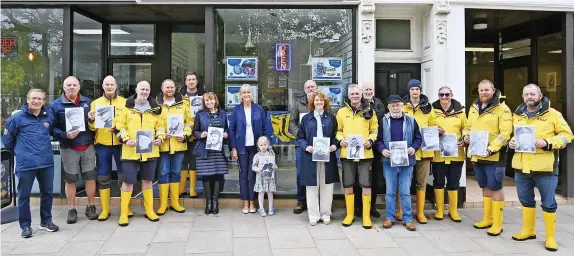  ?? RNLI/Maurice Chittock ?? Families and crew hold photos of Exmouth RNLI 15 coxswains