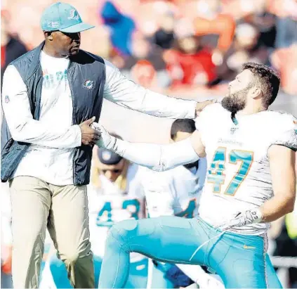  ?? KIRK IRWIN/GETTY ?? Dolphins coach Brian Flores shakes hands with linebacker Vince Biegel during warmups prior to the game against the Browns on Sunday.