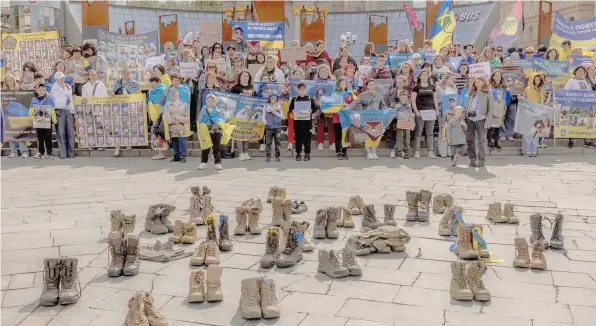  ?? — AFP ?? Relatives and friends of Ukrainian soldiers missing hold portraits and placards during a rally, at Independen­ce Square, in Kyiv.