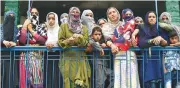  ?? (AFP) ?? Villagers watch the funeral procession for slain militant Showkat Ahmed at Arwani village in Anantnag, Jammu and Kashmir on Tuesday