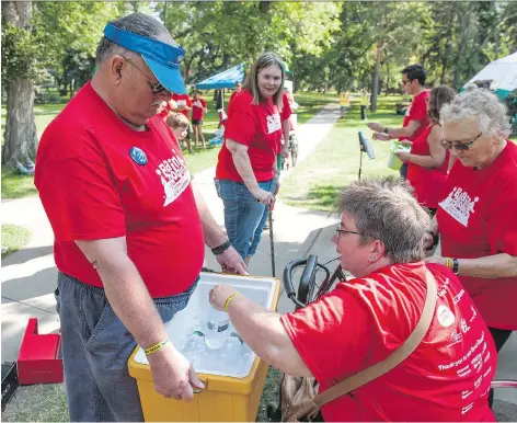  ?? BRANDON HARDER ?? Participan­ts cooled off Saturday after walking around the lake at Wascana Park in 30C° heat during the 15th annual Brain Boogie.